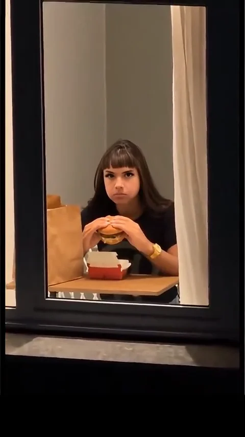 Window peeper AI video still: Roommate staring back from a lit window at night